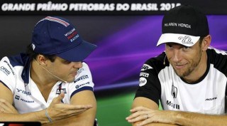 McLaren Formula One driver Button of Britain listens to Williams Formula One driver Massa of Brazil during a news conference for the Brazil F1 Grand Prix in Sao Paulo